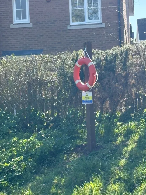Lifebuoy station within landscaped grounds